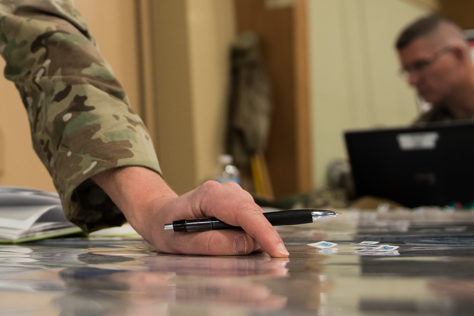 Lt. Col. Matthew Emerson, director of operations for the 146th Air Support Operations Squadron (146th ASOS), Oklahoma Air National Guard, points out a grid coordinate on a map as he plots an airstrike during the 19-05 Command Post Exercise (CPX) for the Minnesota Army National Guard Armored Brigade Combat Team, 34th Infantry Division (1/34th ABCT), March 8-9, 2019, at Camp Ripley in Little Falls, Minn. The CPX was a practice virtual battle exercise for the brigade to practice their battle drills, and the 146th ASOS will continue partnering with the 1/34th ABCT later in the year to assist in a graded warfighter exercise, as well as other trainings next year. (U.S. Air National Guard photo by Staff Sgt. Brigette Waltermire)