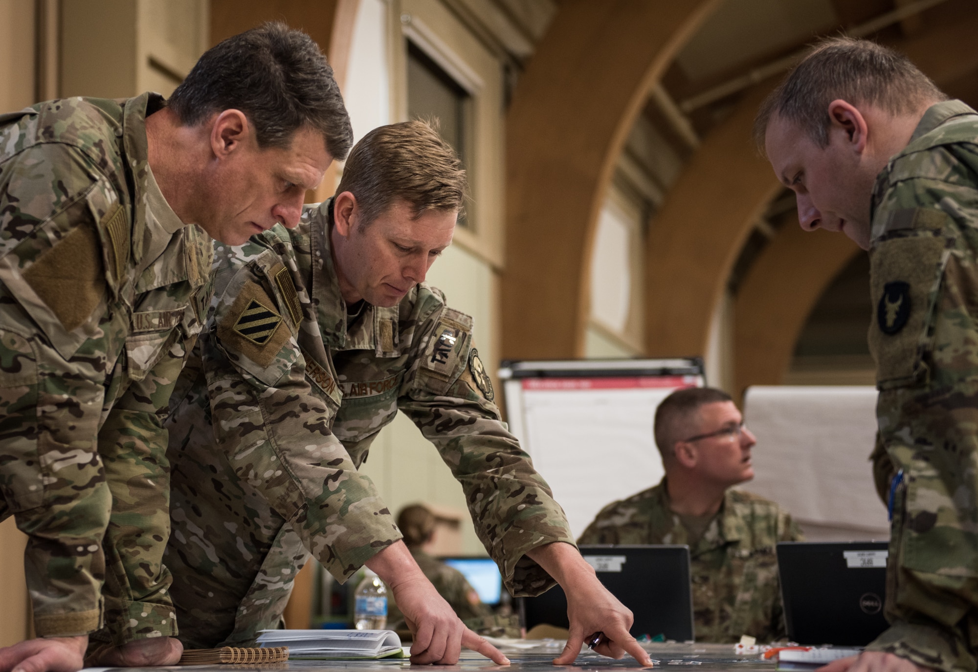 Lt. Col. Matthew Emerson, director of operations for the 146th Air Support Operations Squadron (146th ASOS), Oklahoma Air National Guard, discusses grid coordinates on a map with Maj. Bradley Wallace, brigade fire support officer for the Army National Guard Armored Brigade Combat Team, 34th Infantry Division (1/34th ABCT), and Capt. Trevor Smith, operations flight commander for the 146th ASOS, during the brigade’s 19-05 Command Post Exercise (CPX) March 8-9, 2019, at Camp Ripley in Little Falls, Minn. The CPX was a practice virtual battle exercise for the brigade to practice their battle drills, and the 146th ASOS will continue partnering with the 1/34th ABCT later in the year to assist in a graded warfighter exercise, as well as other trainings next year. (U.S. Air National Guard photo by Staff Sgt. Brigette Waltermire)