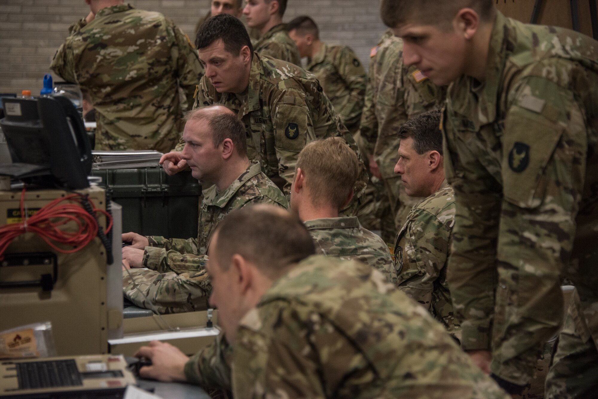 Members of the Army National Guard Armored Brigade Combat Team, 34th Infantry Division (1/34th ABCT), look at computers where a simulated battle is happening in real-time during the 19-05 Command Post Exercise (CPX) for the 1/34th ABCT, March 8-9, 2019, at Camp Ripley in Little Falls, Minn. The CPX was a practice virtual battle exercise for the brigade to practice their battle drills, and the 146th ASOS will continue partnering with the 1/34th ABCT later in the year to assist in a graded warfighter exercise, as well as other trainings next year. (U.S. Air National Guard photo by Staff Sgt. Brigette Waltermire)