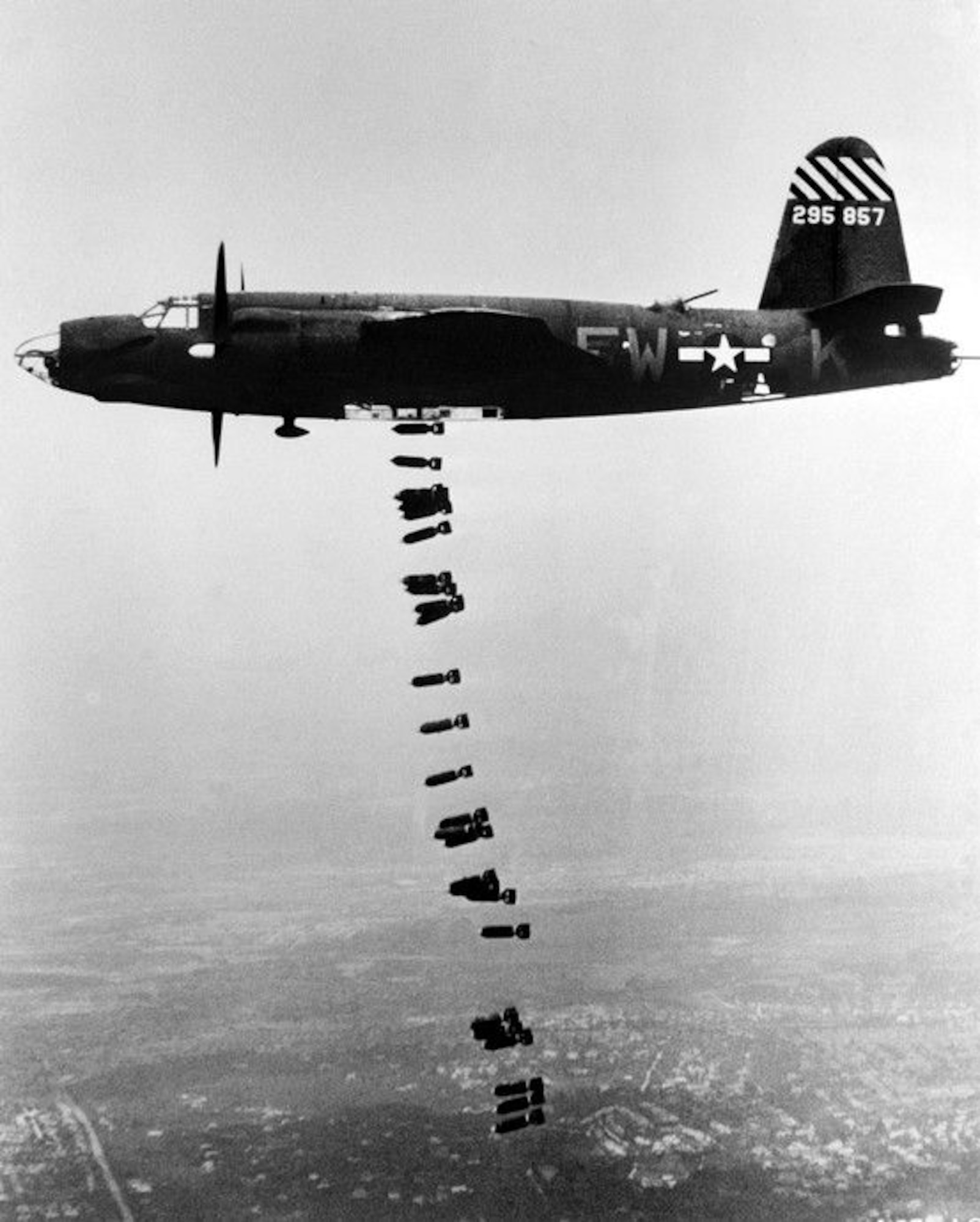 The twin-engine Martin B-26 Marauder medium bomber, assigned to Ninth Air Force, dropping a string of bombs during a mission. The Marauder, flying at medium altitudes of 10,000 to 15,000 feet with fighter escorts proved to be the most accurate attack aircraft used during the conduct of the Transportation Plan. (USAAF archival photo)