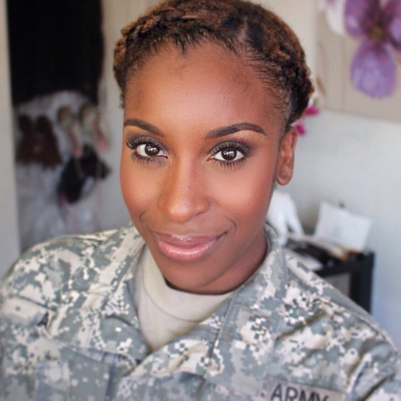 Female soldier in camouflage uniform poses for a selfie.