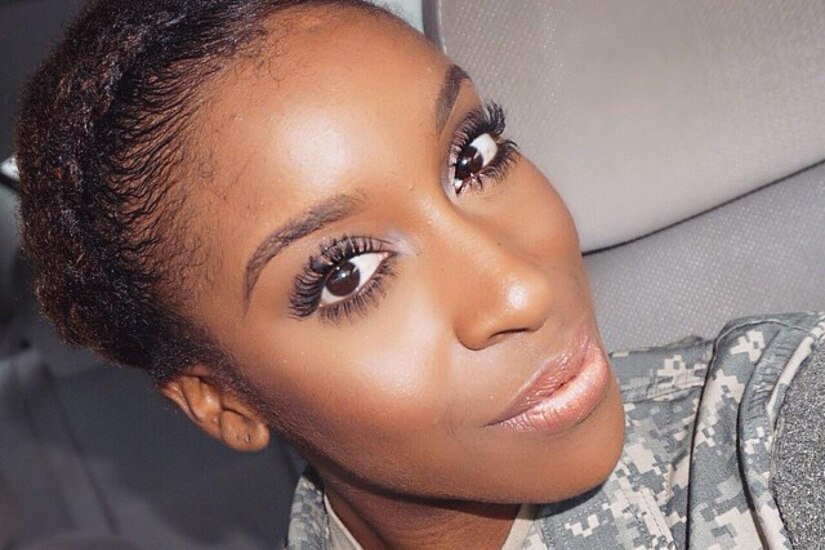 Female soldier in camouflage uniform poses for a selfie.