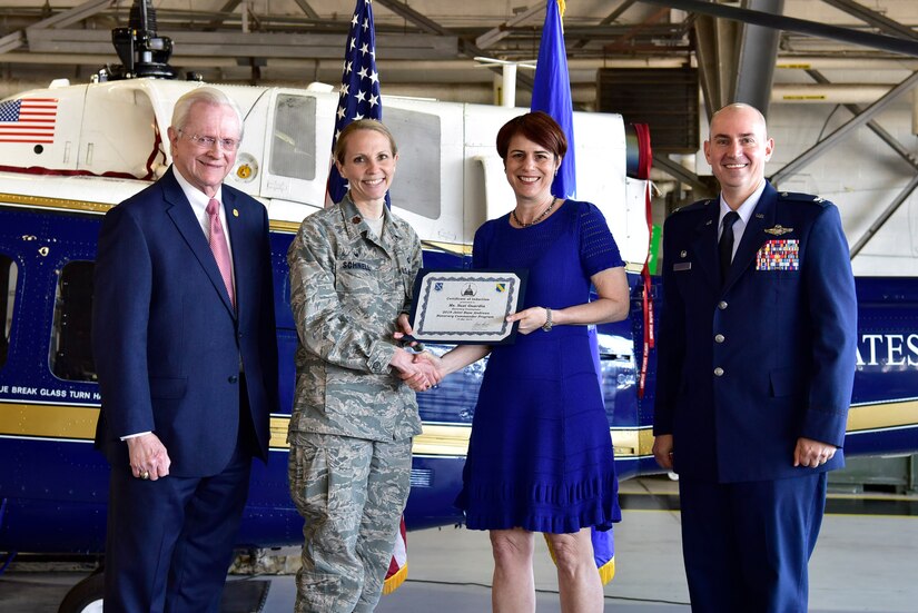 Suzi Guardia, center right, Senior Advisor for Neighbor Engagement, Blue Star Families, receives a certificate from Maj. Kristen Schnell, center left, 11th Comptroller Squadron commander, as Col. Andrew Purath, far right, 11th Wing and Joint Base Andrews commander, and Jim Estepp, far left, President and CEO of the Greater Prince George’s Business Roundtable, look on at Hangar One on JBA, Md., March 19, 2019. Honorary Commanders are selected leaders from the local community who help strengthen the relationship between military members and the community. (U.S. Air Force photo taken by Airman 1st Class Noah Sudolcan)