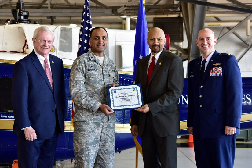 Franklyn Johnson, center right, Manager Edible Arrangements in Suitland Maryland, receives a certificate from Col. Amar Kosaraju, center left, 11th Dental Squadron commander as Col. Andrew Purath, far right, 11th Wing and Joint Base Andrews commander, and Jim Estepp, far left, President and CEO of the Greater Prince George’s Business Roundtable, look on at Hangar One on JBA, Md., March 19, 2019. The JBA Honorary Commanders Program gives the local community an opportunity to build a relationship with the base and its people. (U.S. Air Force photo taken by Airman 1st Class Noah Sudolcan)