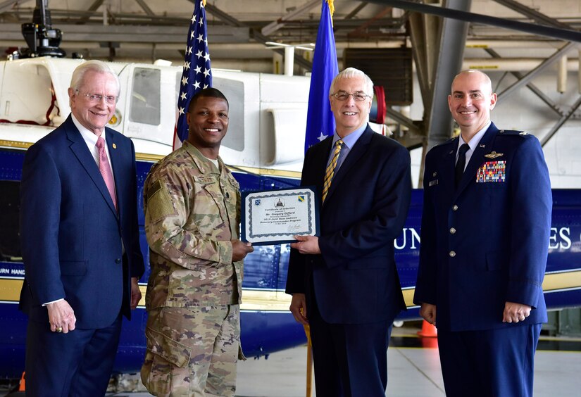 Dr. Gregory Gifford, center right, Senior Pastor and School Chancellor of Riverdale Ministries, receives a certificate from Lt. Col. Julian Gaither, center left, Chief of Chaplains as Col. Andrew Purath, far right, 11th Wing and Joint Base Andrews commander, and Jim Estepp, far left, President and CEO of the Greater Prince George’s Business Roundtable, look on at Hangar One on JBA, Md., March 19, 2019. The Honorary Commanders Program partners key leaders on JBA with community leaders in the local area. (U.S. Air Force photo taken by Airman 1st Class Noah Sudolcan)