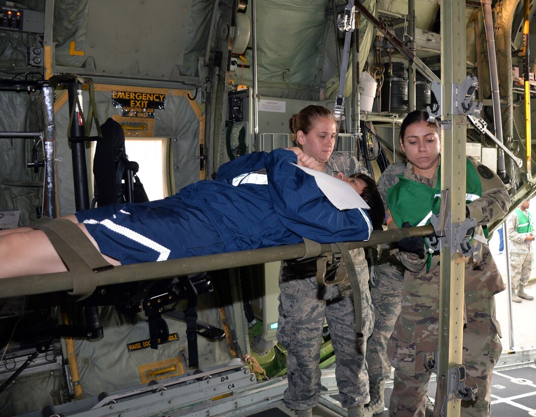 Senior Airman Amanda Geffert, 433rd Aeromedical Evacuation Squadron flight medic, and Army Spc. Maryssa Alfonso, BAMC Alpha Company load a simulated litter patient into a C-130H Hercules aircraft to for air transport at Joint Base San Antonio-Lackland, Texas March 20, 2019.