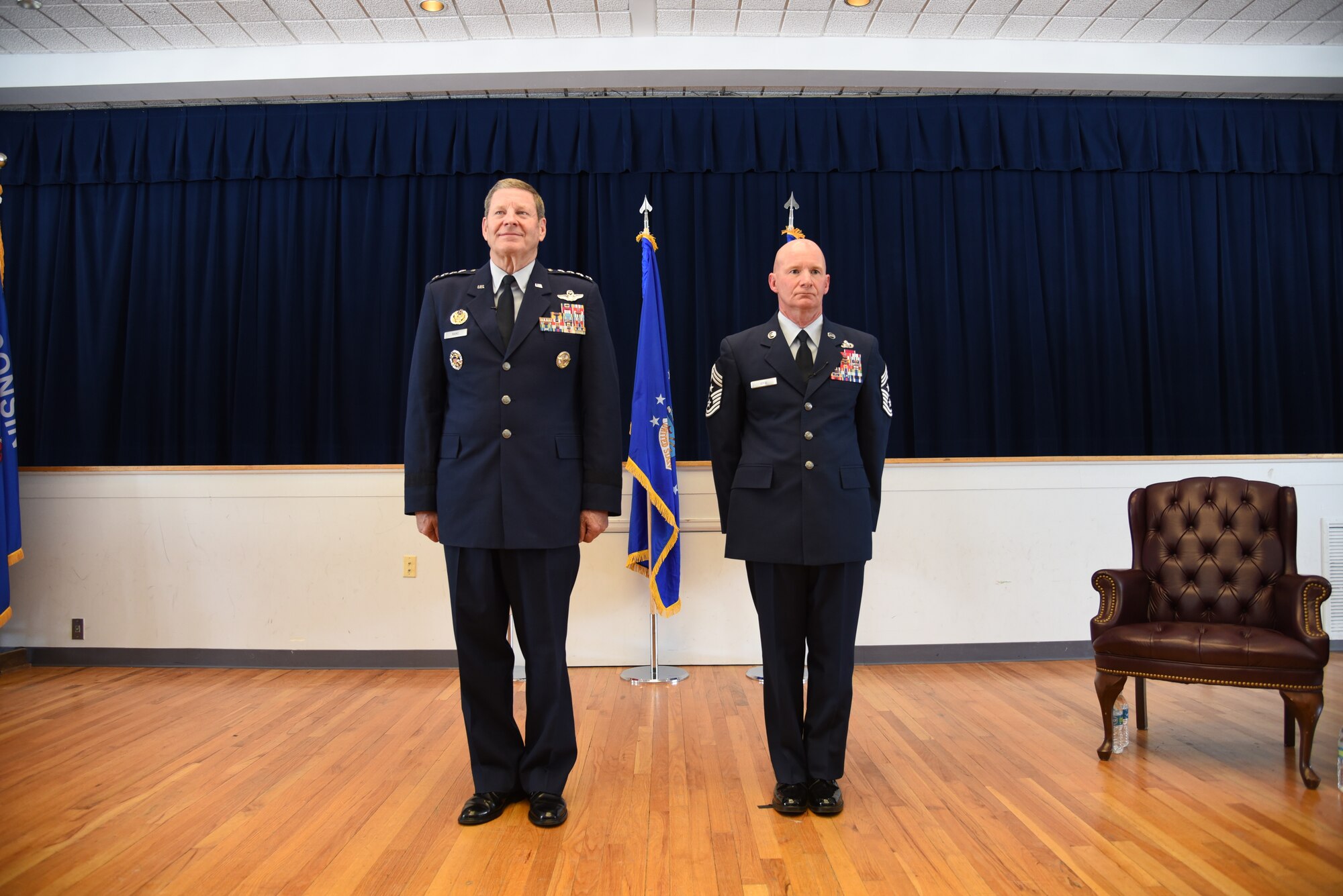 Retired Gen. Robin Rand and Chief Master Sgt. Thomas F. Good, 20th Air Force command chief, stand at attention during Chief Good's retirement ceremony March 5, 2019, at F. E. Warren Air Force Base. Chief Good retired as the 20th Air Force command chief in the presence of his wife, children and friends. (U.S. Air Force photo by Senior Airman Nicole Reed)