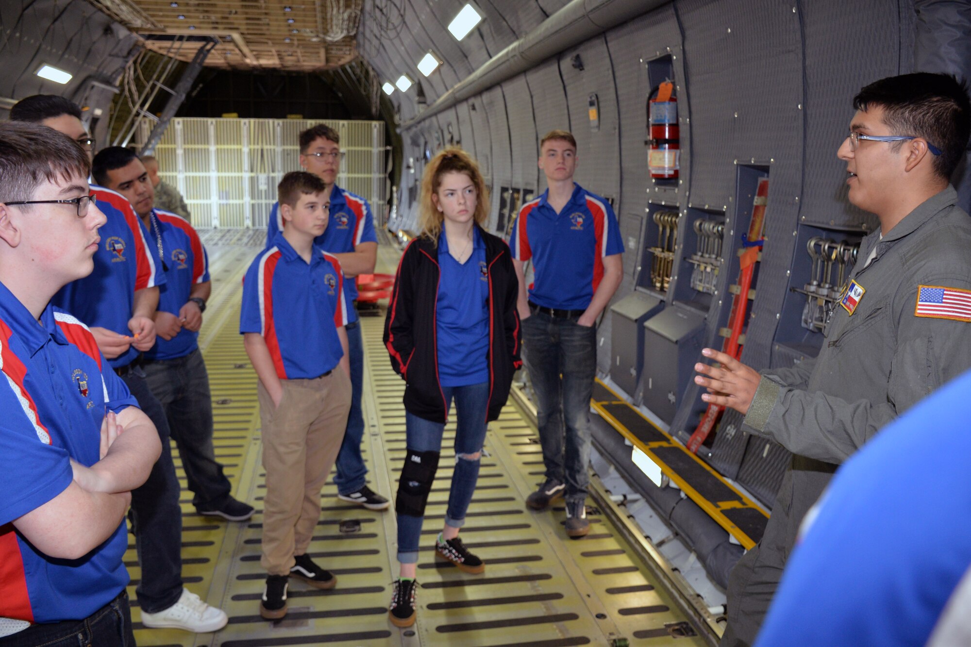 Senior Airman Andres M. Terrazas, 68th Airlift Squadron loadmaster, describes the features of a C-5M Super Galaxy cargo deck to Burleson Independent School District Air Force Junior ROTC students March 22, 2019 at Joint Base San Antonio-Lackland, Texas.