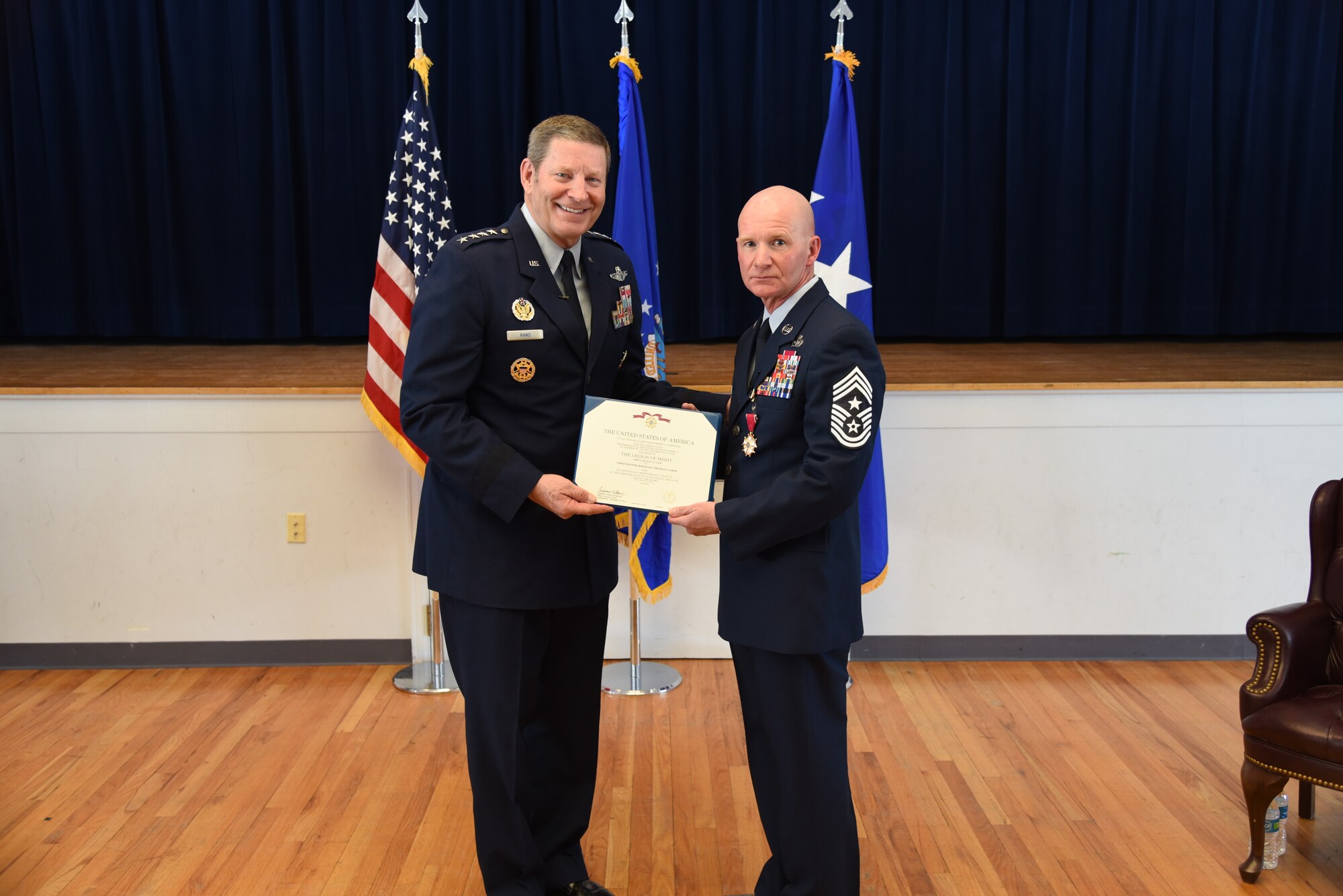Retired Gen. Robin Rand presents a certificate to Chief Master Sgt. Thomas F. Good, 20th Air Force command chief, during Chief Good's retirement ceremony March 5, 2019, at F. E. Warren Air Force Base. Chief Good retired as the 20th Air Force command chief in the presence of his wife, children and friends. (U.S. Air Force photo by Senior Airman Nicole Reed)