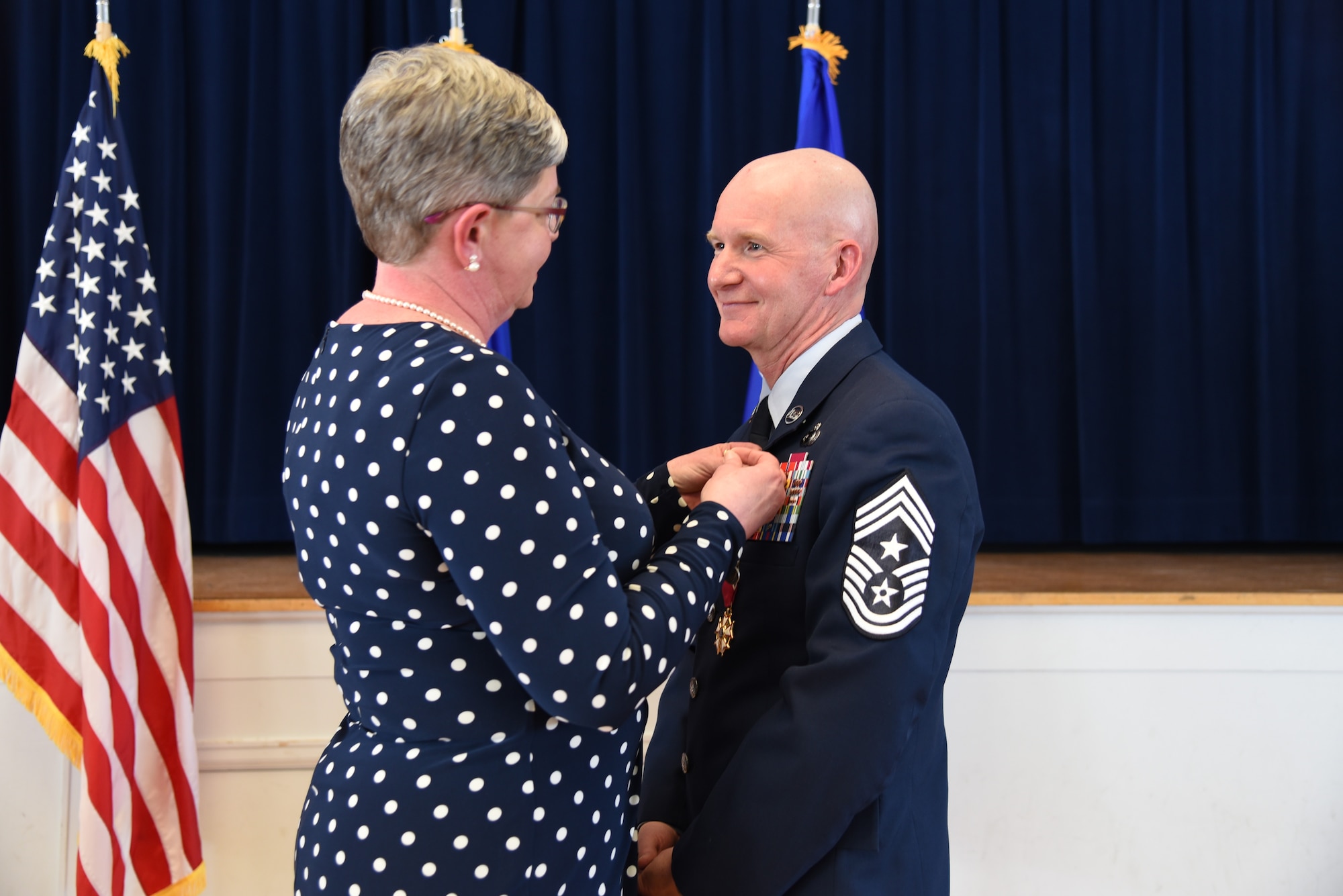 Tennie Good pins on the retirement pin on the lapel of Chief Master Sgt. Thomas F. Good, 20th Air Force command chief, during his retirement ceremony March 5, 2019, at F. E. Warren Air Force Base, Wyo. Chief Good retired as the 20th Air Force command chief in the presence of his wife, children and friends. (U.S. Air Force photo by Senior Airman Nicole Reed)