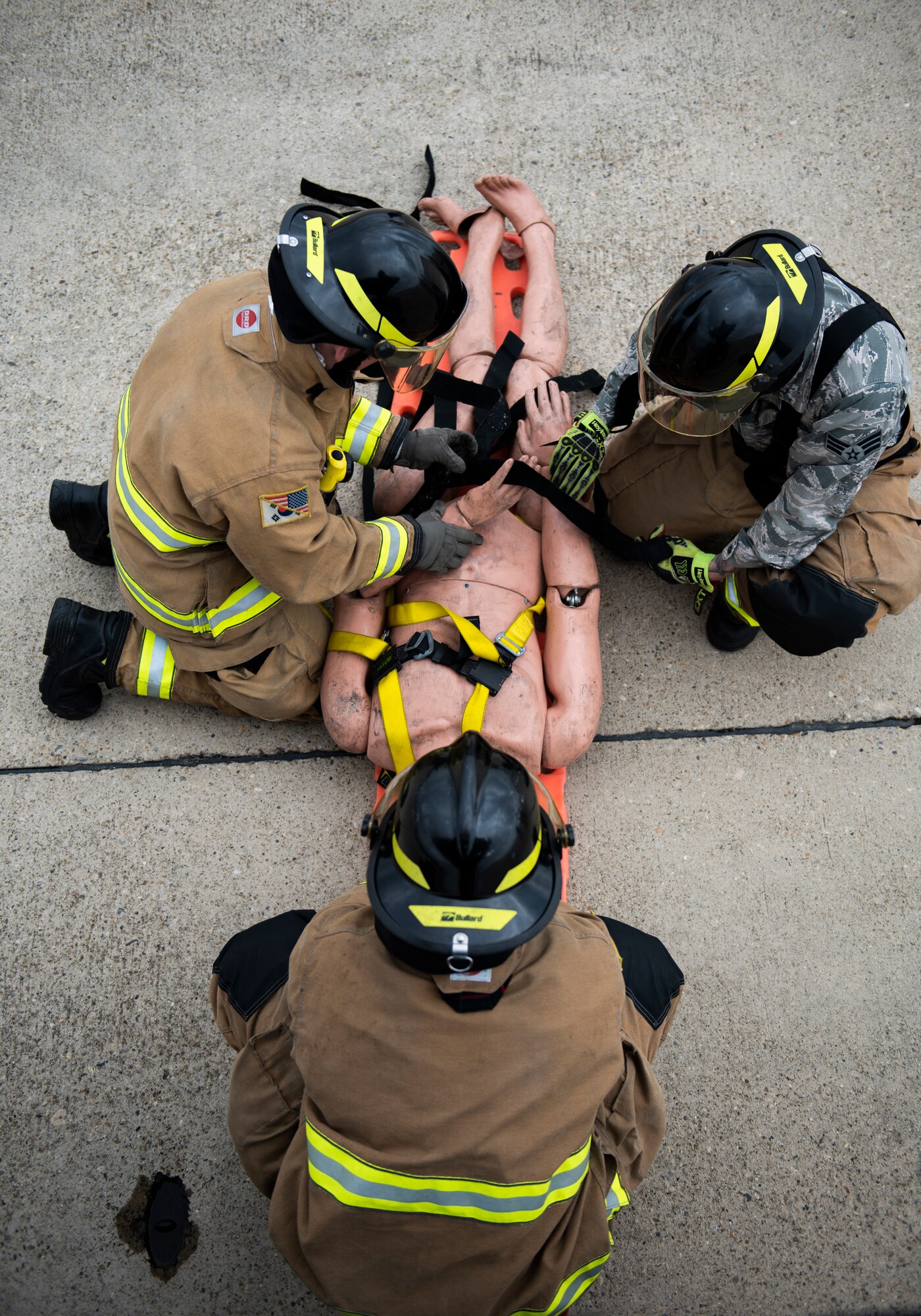 Fire fighters from the 8th Civil Engineer Squadron secure a mannequin simulating a fall victim at Kunsan Air Base, Republic of Korea, March 26, 2019. The fire department responded to the call in minutes to be on scene and rescue the victim as quickly and safely as possible. (U.S. Air Force phot by Senior Airman Stefan Alvarez)