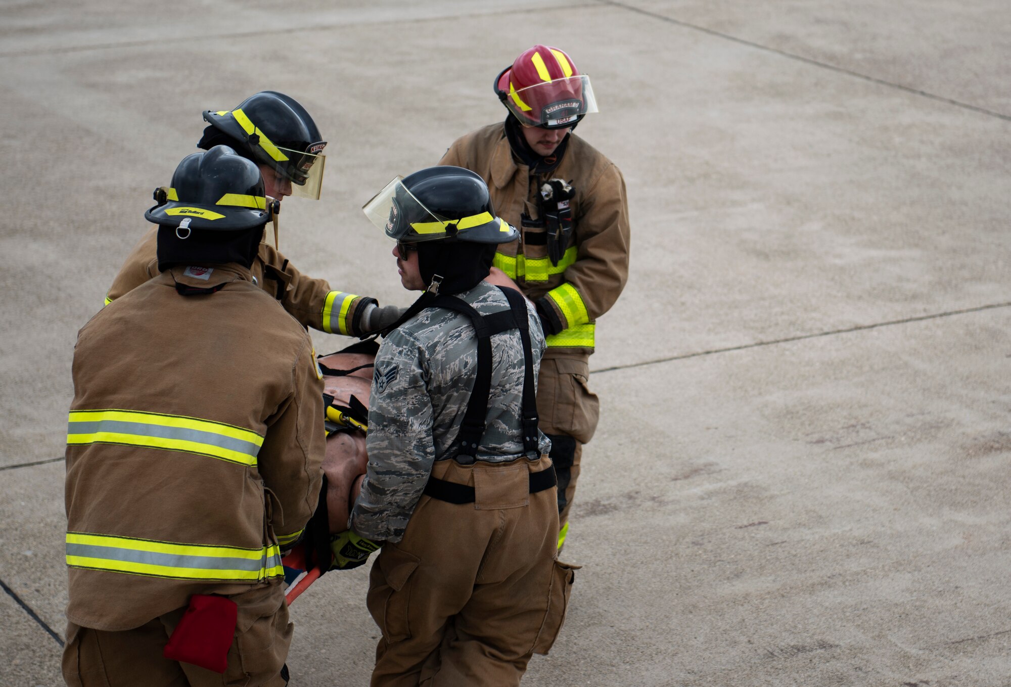 Fire fighters from the 8th Civil Engineer Squadron carry a mannequin simulating a fall victim at Kunsan Air Base, Republic of Korea, March 26, 2019. Fall victims can have various types of injuries that are not always visible so extra precaution is taken to not agitate any injuries. (U.S. Air Force phot by Senior Airman Stefan Alvarez)