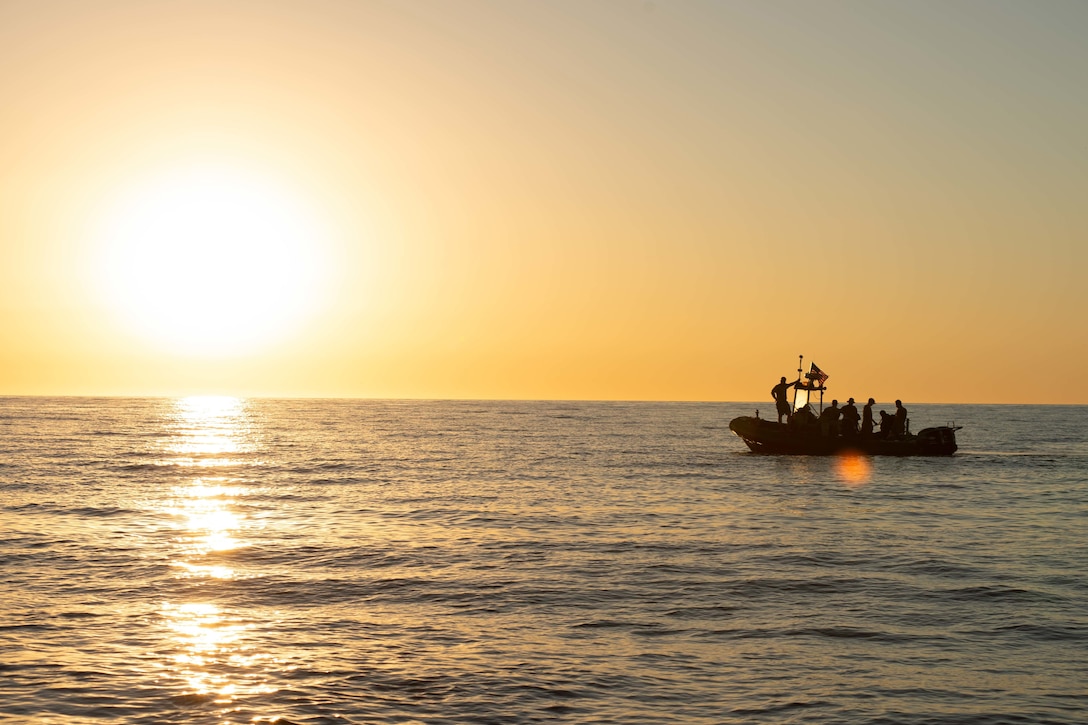 A small boat floats in the water at twilight.