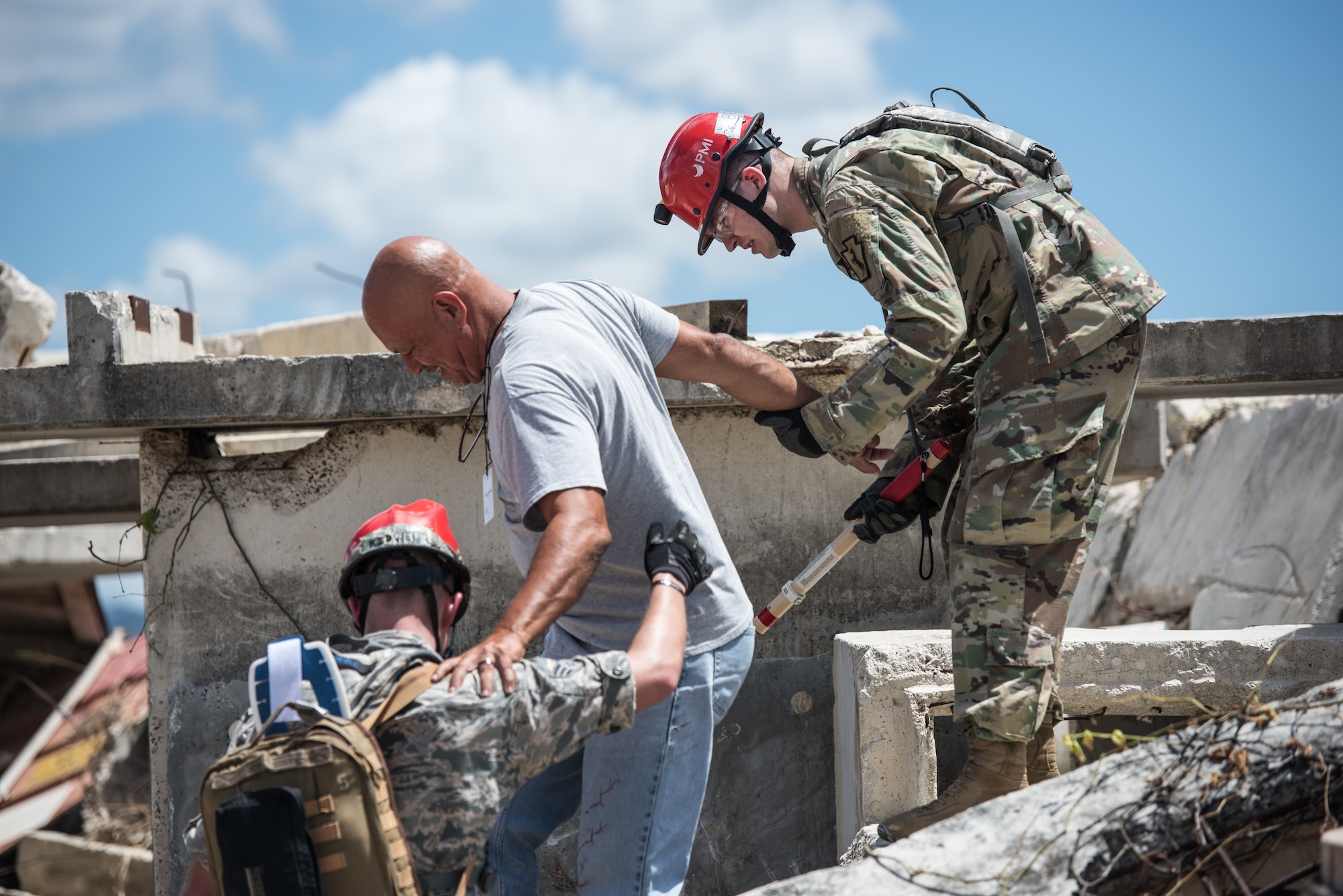 A U.S. Airman and Soldier from the 3rd Chemical, Biological, Radiological, Nuclear Task Force  search and extraction team, Pennsylvania National Guard, help a casualty actor descend down from a rubble pile during the exercise Vigilant Guard.