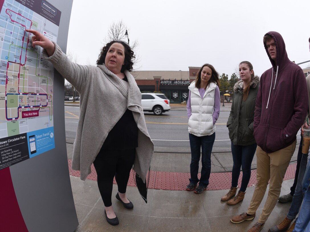 Cristy Ksepka, certified tourism ambassador for the Oklahoma City Convention and Visitors Bureau, left, points out details of the OKC Streetcar routes to Airmen attending a special tour meant to connect them to their new city on March 8, 2019.
