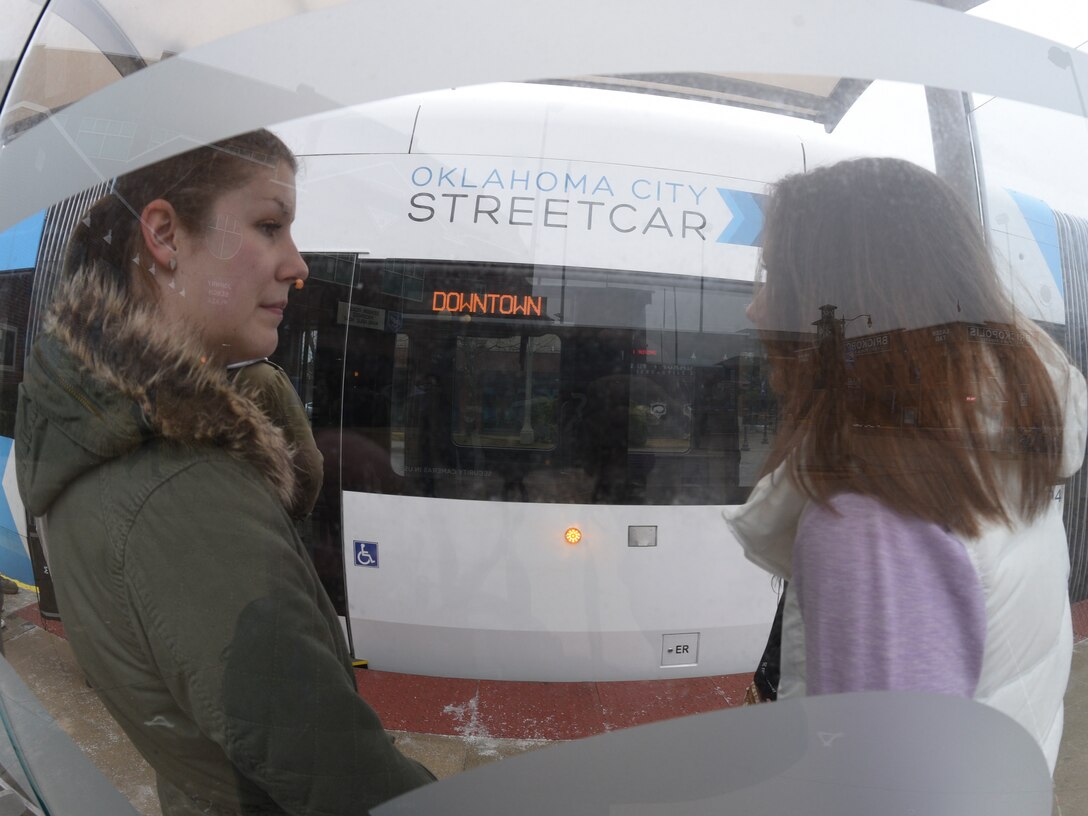 Airman 1st Class Cosette Dahlvang, left, 552nd Maintenance Group aircraft parts store apprentice, and Airman 1st Class Karie Mees, 72nd Security Forces Squadron installation entry controller, talk to each other at the Mickey Mantle stop for the Oklahoma City Streetcar during a tour of downtown on March 8, 2019.
