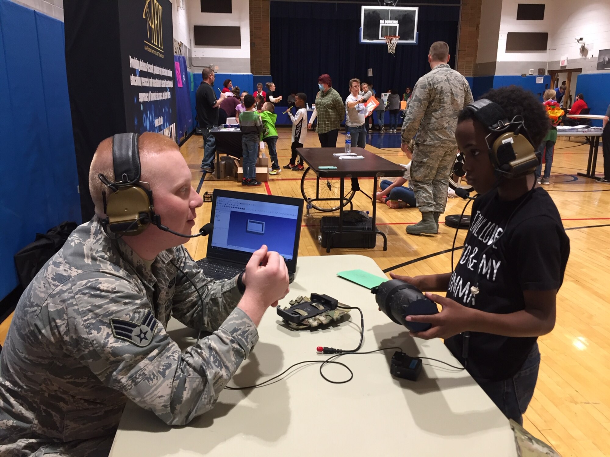 Senior Airman Brad Nimmo, a scientific applications specialist who works in the Air Force Research Laboratory's 711th Human Performance Wing's BATMAN (Battlefield Air Targeting Man-Aided kNowledge) program, shows Aiden Cole a plasma shield during STEM 3.14 Fest at the Youth Center at Wright-Patterson Air Force Base. (Skywrighter photo/Amy Rollins)