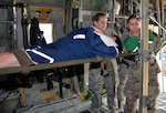 Senior Airman Amanda Geffert, 433rd Aeromedical Evacuation Squadron flight medic, and Army Spc. Maryssa Alfonso, BAMC Alpha Company load a simulated litter patient into a C-130H Hercules aircraft to for air transport at Joint Base San Antonio-Lackland March 20. Several military and civilian organizations participated in a National Disaster Medical System exercise.