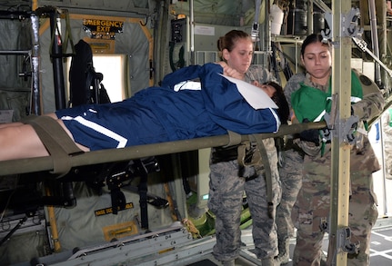 Senior Airman Amanda Geffert, 433rd Aeromedical Evacuation Squadron flight medic, and Army Spc. Maryssa Alfonso, BAMC Alpha Company load a simulated litter patient into a C-130H Hercules aircraft to for air transport at Joint Base San Antonio-Lackland March 20. Several military and civilian organizations participated in a National Disaster Medical System exercise.