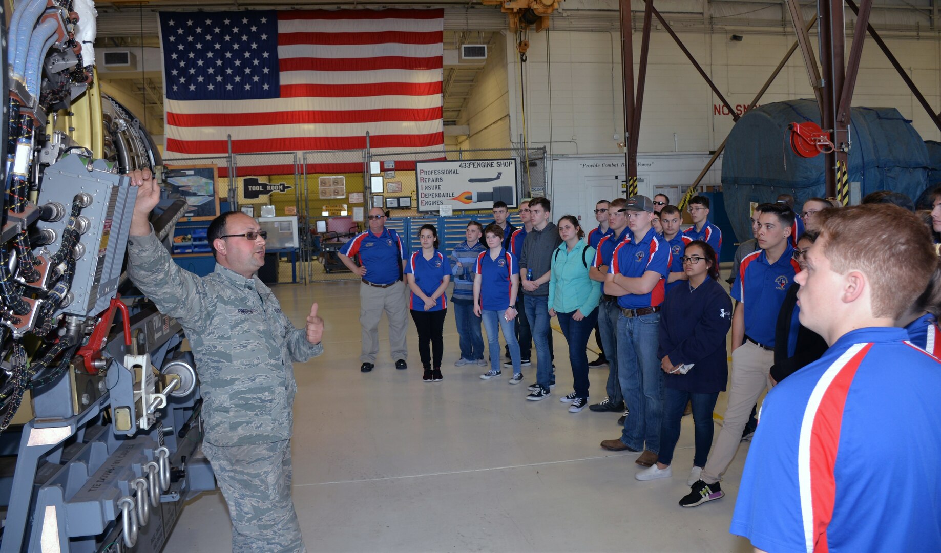 Master Sgt. Sean C. Preston, 433rd Maintenance Squadron propulsion mechanic, describes the features of a C-5M Super Galaxy engine to Burleson Independent School District Air Force Junior ROTC students March 22 at Joint Base San Antonio-Lackland. Fifty-four students and instructors from Burleson, Texas, attended the basic military training and toured several organization on base during their visit.