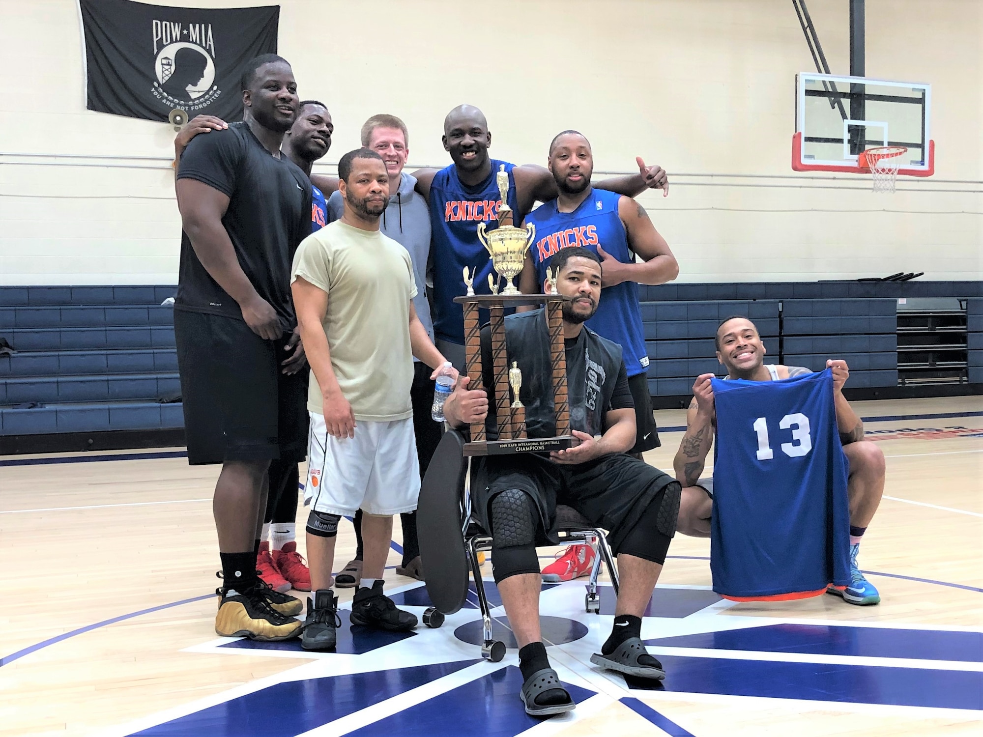 The title-winning CPTS/FSS team moments after receiving the base trophy after their 49-38 victory over SFS Jones March 21 at the West Fitness Center. From left to right:  Johnny Harris, Staff Sgt. Marcus Amerson, Staff Sgt. Joel Gardner, Capt. Jeremy Driggs, Senior Airman Ricky Jackson, Petty Office 1st Class Terrell Dixon, Tech. Sgt. Christopher Clark (with trophy) and Staff Sgt. JD Strong II, who is holding up a number 13 for the absent Airman 1st Class Austin Prisbrey. (U.S. Air Force photo by Jim Fisher)