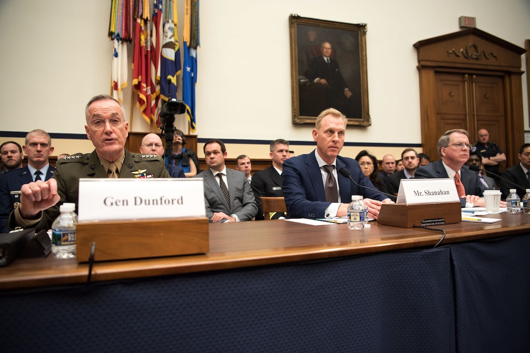 Acting Defense Secretary Patrick M. Shanahan, Marine Corps Gen. Joe Dunford and David L. Norquist sit at a table alongside each other.