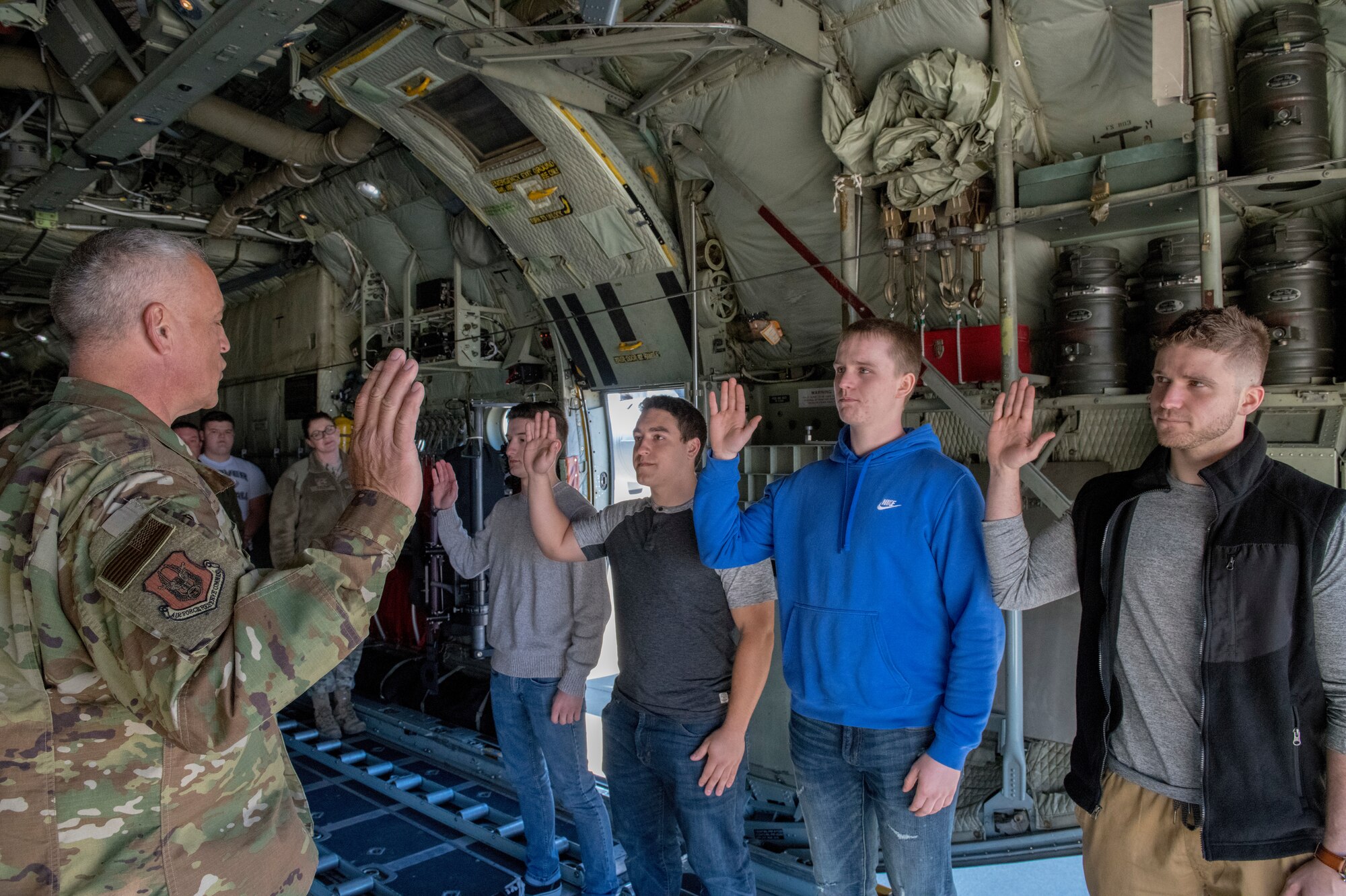 Lt. Col. Benjamin Rivera, wing inspection team chief for the 911th Airlift Wing, administers the oath of enlistment to Bailey Shirey, Benjamin Rivera Jr. (Lt. Col. Rivera's son), Vincent McGreal and Daniel Day on the ramp of a C-130H Hercules aircraft here, March 26, 2019.