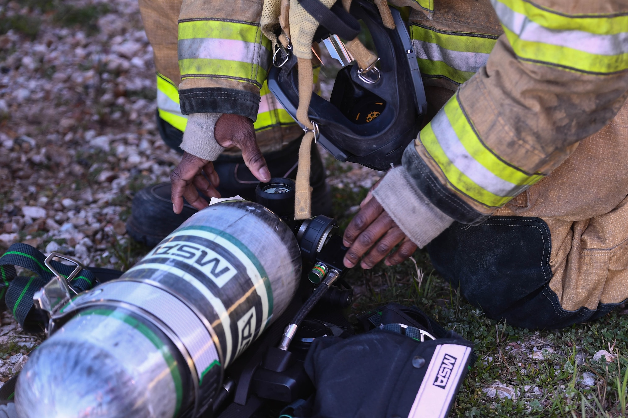 A Shreveport Fire Department firefighter checks over his gear before a live fire training exercise March 21, 2019, at Barksdale Air Force Base, Louisiana. Shreveport Fire Department conducts simulated aircraft fires every year with the 2nd Civil Engineering Squadron Fire Department. (U.S. Air Force photo by Airman Jacob B. Wrightsman)