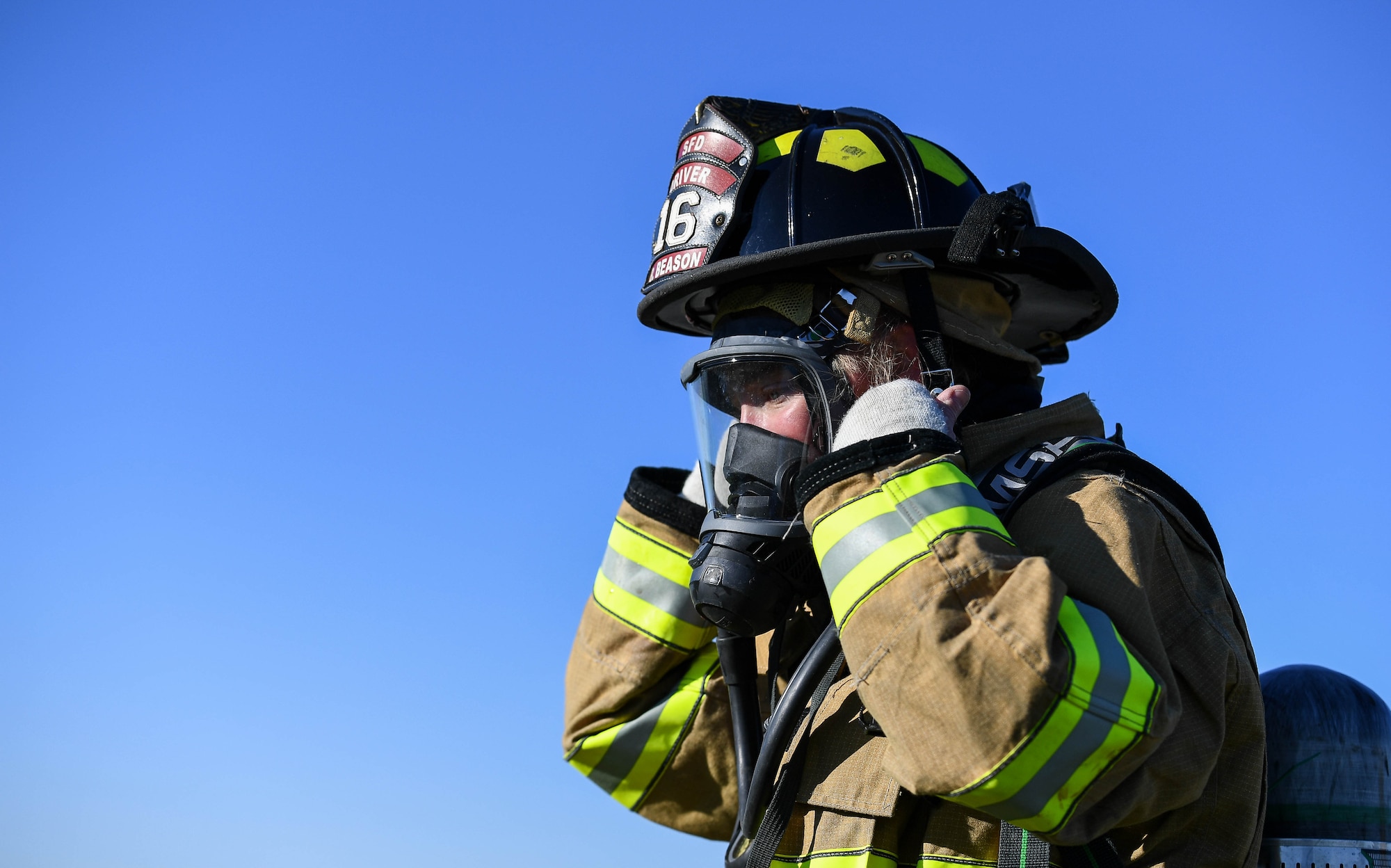 A Shreveport Fire Department firefighter adjusts her headgear during a live fire training exercise March 21, 2019, at Barksdale Air Force Base, Louisiana. Shreveport Fire Department conducts annual live fire training to complete their Federal Aviation Administration required training. (U.S. Air Force photo by Airman Jacob B. Wrightsman)