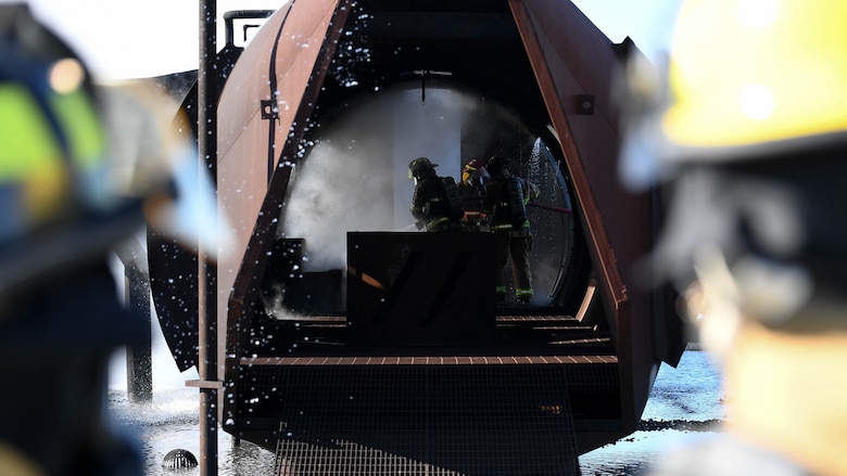 U.S. Air Force firefighters from the 2nd Civil Engineering Squadron and firefighters from the Shreveport Fire Department put out a fire during a live fire training exercise March 21, 2019, at Barksdale Air Force Base, Louisiana. The interior of the training aircraft is designed to test firefighters with simulated cargo and cockpit fires. (U.S. Air Force photo by Airman Jacob B. Wrightsman)
