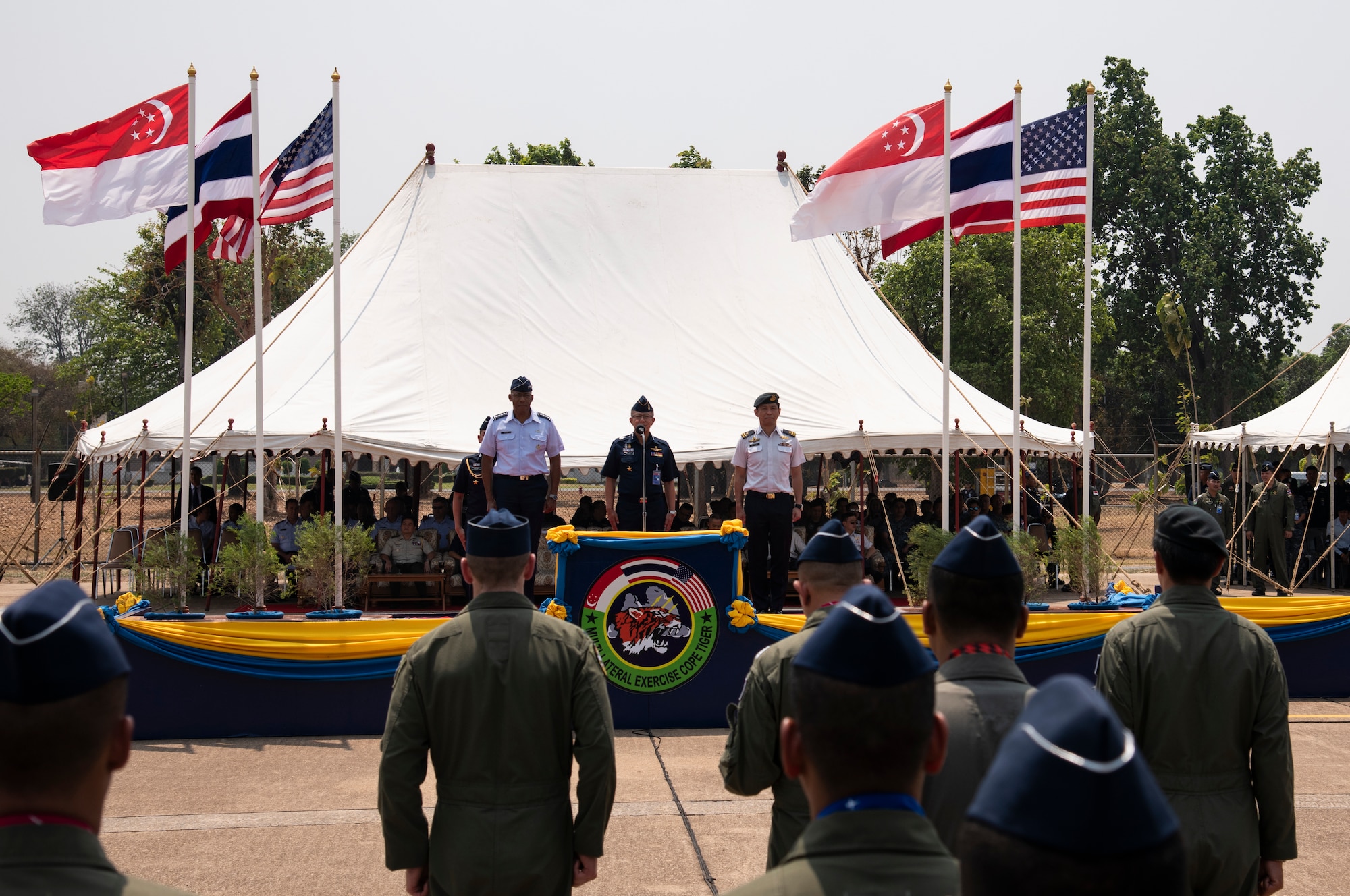 U.S. Air Force Gen. CQ Brown Jr., Pacific Air Forces commander, Royal Thai Air Force Air Chief Marshal Chaiyapruk Didyasarin, commander-in-chief, and Republic of Singapore Air Force Brigadier General Tommy Tan Ah Han, chief of staff–air staff, stand at attention during the closing ceremony of COPE Tiger 2019 at Korat Royal Thai Air Force Base, Thailand, March 22, 2019.