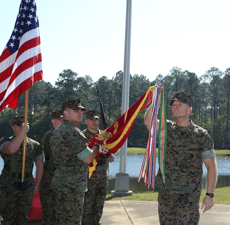 Brig. Gen. Joseph F. Shrader, commanding general, Marine Corps Logistics Command, attaches the Meritorious Unit Commendation with bronze star in lieu of fourth award to the organizational colors during a ceremony held at Covella Pond aboard Marine Corps Logistics Base Albany, March 21.