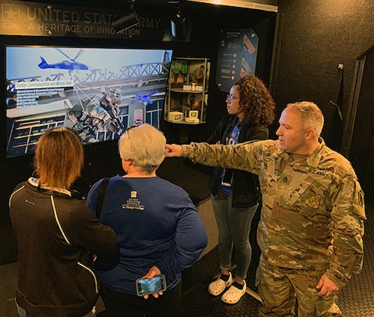 Sgt. 1st Class Richard Sullins, STEM mobile exhibit operator with Mission Support Battalion, explains the technological advancements for the future Soldier during a video presentation inside the STEM mobile exhibit.