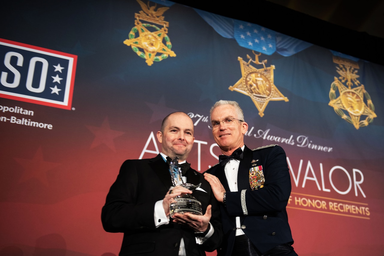 Air Force Gen. Paul J. Selva, vice chairman of the Joint Chiefs of Staff, stands next to a man holding an award