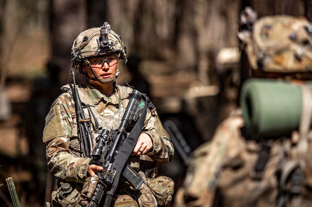 A soldier stands holding a weapon.