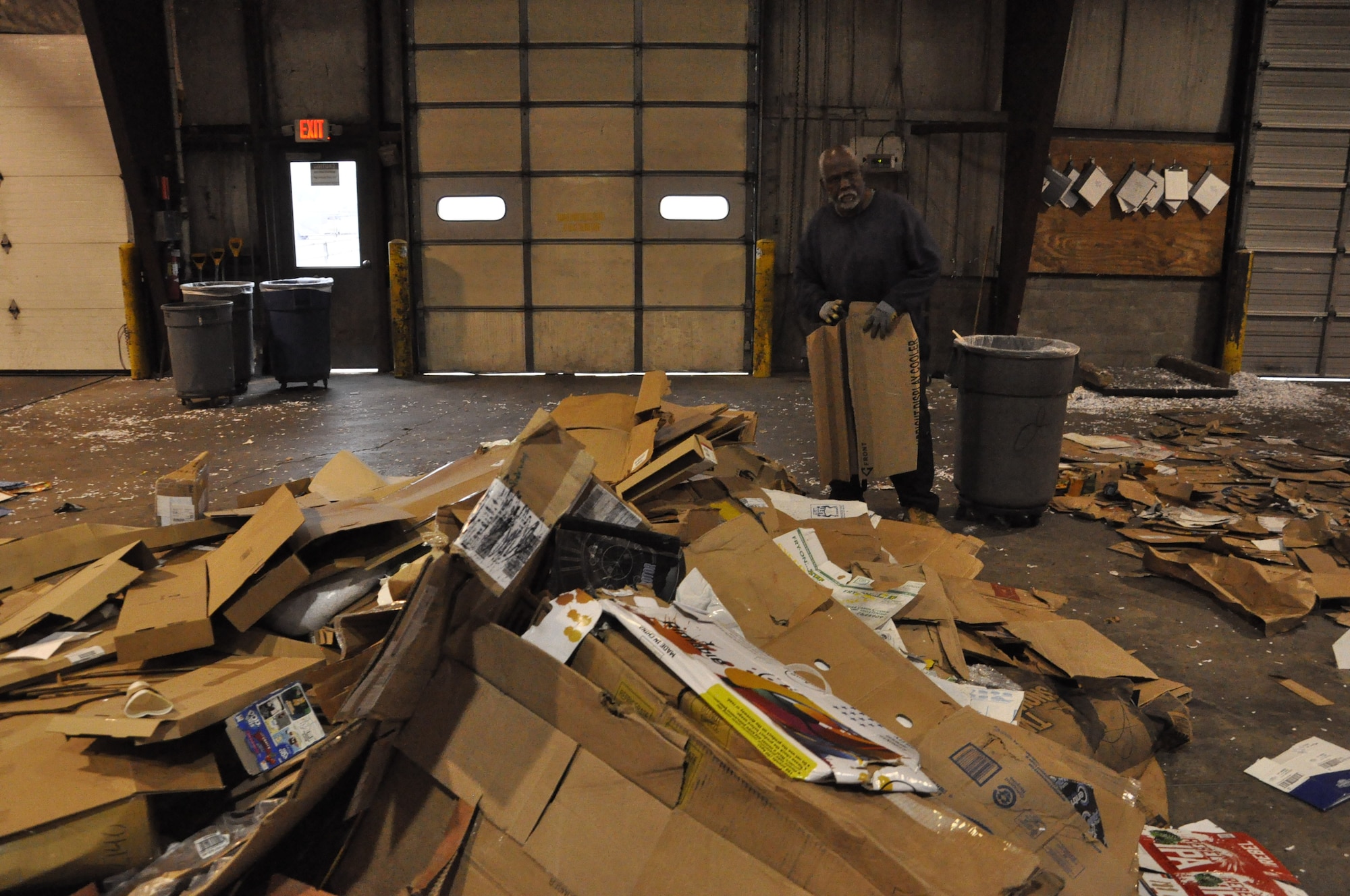 Joseph Reeves, recycling handler at the base recycling center, hand sorts corrugated cardboard for recycling which greatly increases manpower cost. (U.S. Air Force photo/Gene Barnett)