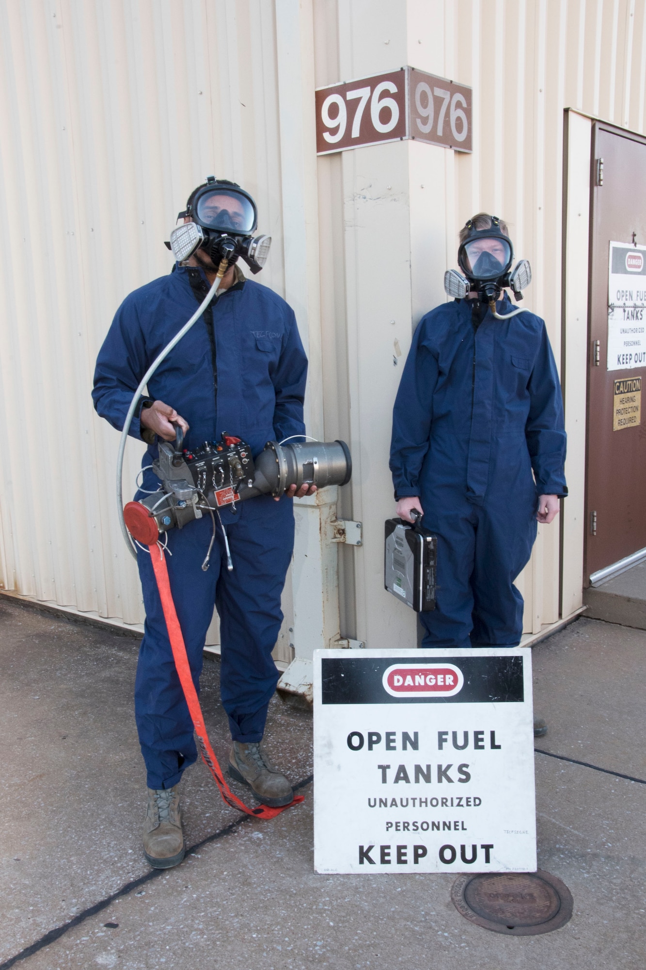 Airmen 1st Class Elijah Brown and Steven Graves prepare to enter the fuel tanks for the Boeing E-3 Sentry Airborne Warning and Control System. Airmen must wear these GORE-TEX textured suits and ventilators to protect their respiratory systems and skin from the fuel and toxins while working on the aircraft fuel systems (U.S. Air Force photo/2nd Lt. Ashlyn K. Paulson)