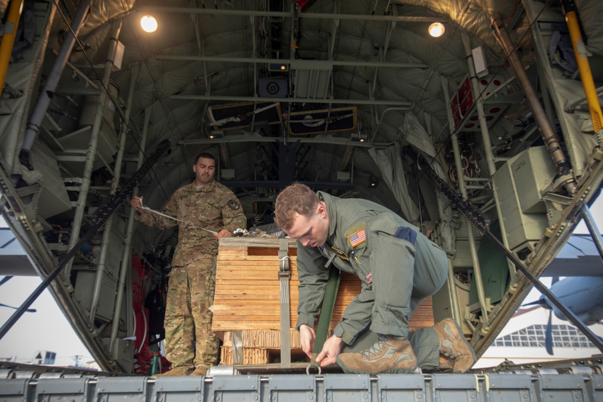 (Right to left) Airman 1st Class Matthew Pfeffer and Tech. Sgt. Brian Gates, 36th Airlift Squadron C-130J loadmasters