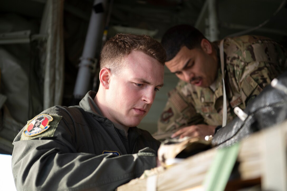 (Front to back) Airman 1st Class Matthew Pfeffer and Tech. Sgt. Brian Gates, 36th Airlift Squadron C-130J loadmasters