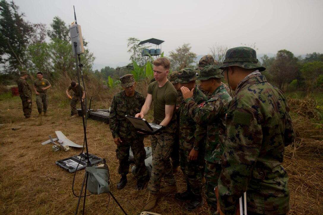 U.S. Marine Cpl. Kyle Bougeno with 3rd Battalion, 3rd Marine Regiment, explains the use of a laptop and its various video feed capabilities to Royal Thai counterparts at Camp Ban Chan Khrem, the Kingdom of Thailand, Feb. 19, 2018.Bougeno, a Pevely, Missouri native, serves as an intelligence analyst and a small unmanned aerial systems operator. Cobra Gold 18 is an annual exercise conducted in the Kingdom of Thailand and runs from Feb. 13-23 with seven full participating nations. (U.S. Marine Corps photo by Sgt. Robert Arellano)