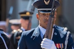 An airman holds a rifle while standing at attention during a ceremony at the Pentagon.