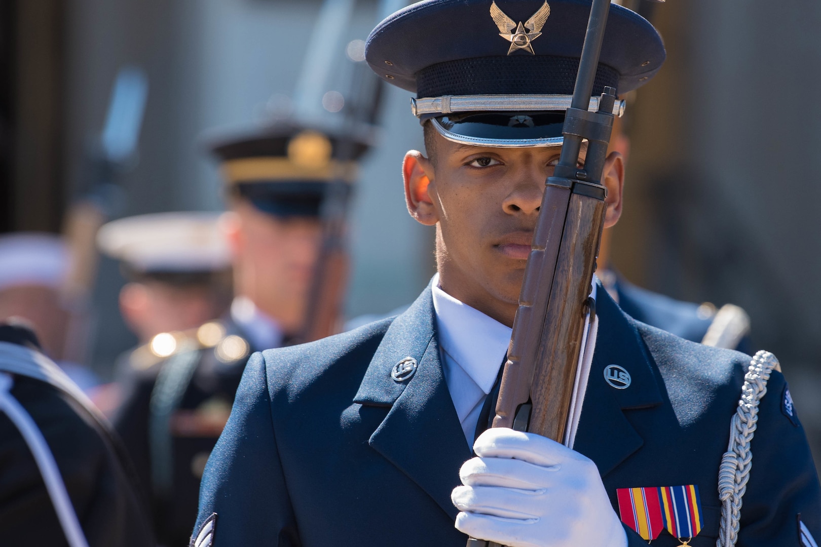 An airman holds a rifle while standing at attention during a ceremony at the Pentagon.