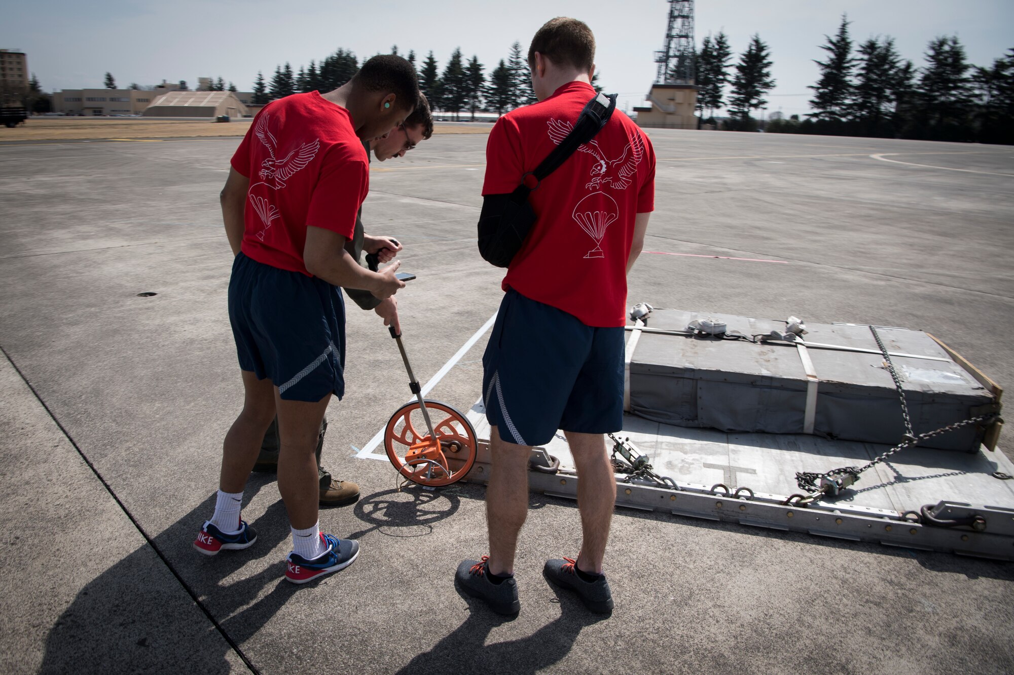 Ground crews with the 36th Airlift Squadron measure the distance of a training pallet from the designated target after a combat offload during the Yokota C-130J Rodeo March 22, 2019, at Yokota Air Base, Japan. The rodeo is a friendly competition between flights within the 36th Airlift Squadron and the 374th Operations Support Squadron that promotes tactical readiness and execution of various airlift capabilities. (U.S. Air Force photo by Senior Airman Donald Hudson)