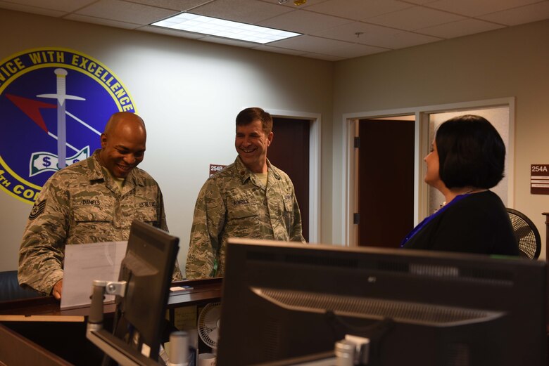 Tech. Sgt. Aubery Daniels, 14th Flying Training Wing Chapel NCO in charge of readiness and resources, and Chaplain (Maj.) Bradley Kimble, 14th FTW deputy chaplain, talk with Lorena Brady, 14th Comptroller Squadron unit program coordinator, March 25, 2019, on Columbus Air Force Base, Mississippi. The chapel team makes sure to talk and get to know Airmen from every shop on base through programs, events and walk-throughs. (U.S. Air Force photo by Senior Airman Beaux Hebert)