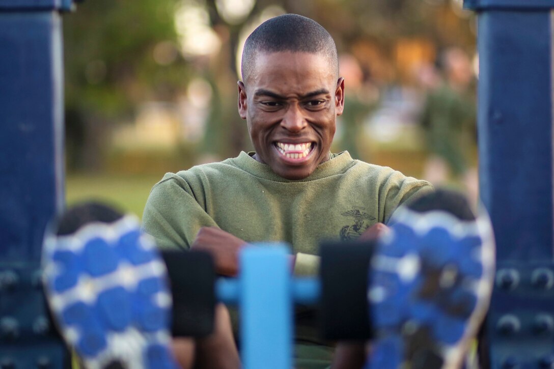 A Marine grimaces as he works out during a fitness program.