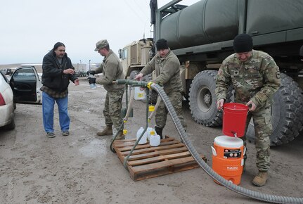 South Dakota Army National Guard Soldiers Spc. Tracy Lennick, Sgt. David Fuegen and Lt. Col. Lew Weber fill containers with drinkable water for residents of Sharps Corner on the Pine Ridge Reservation, S.D., March 25, 2019. Thirteen SDARNG Soldiers with Company A, 139th Brigade Support Battalion, were activated for state duty in Pine Ridge after a county waterline failed due to extreme flooding leaving residents in seven communities without water in their homes.