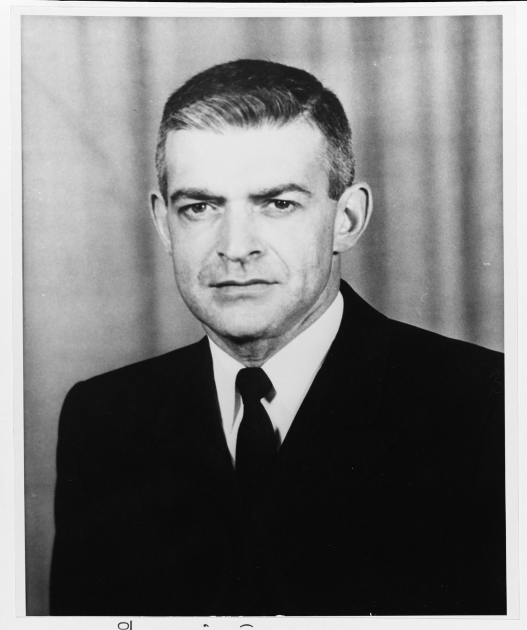 A headshot of a man in suit and tie.