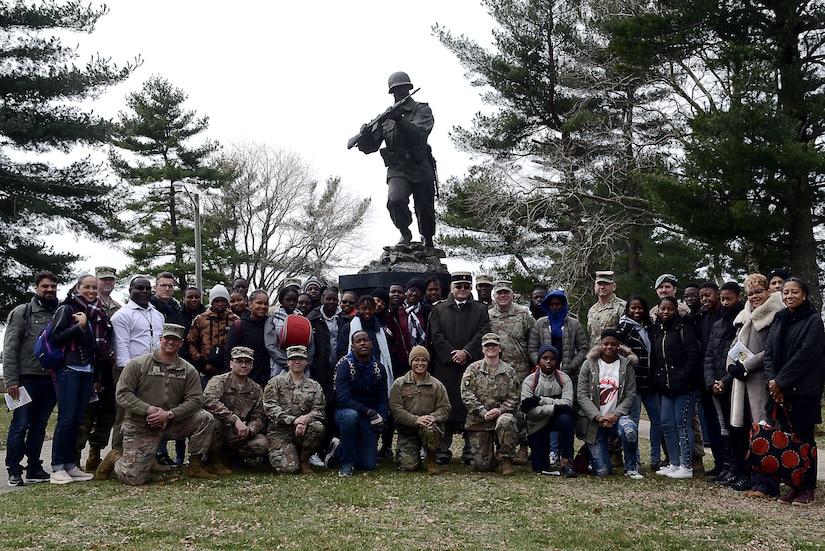 Participants of a French dissident remembrance ceremony pose for a photo in front of the Ultimate Weapon statue at Joint Base McGuire-Dix-Lakehurst, N.J., March 25, 2019. The dissidents were French Caribbean citizens who escaped their island’s pro-Nazi policies in the 1940s to fight alongside the United States in World War II. Participants of the ceremony included a group of French students from Martinique who laid a wreath of remembrance for the French dissidents that trained at Fort Dix. (U.S. Air Force photo by Tech. Sgt. Austin Knox)