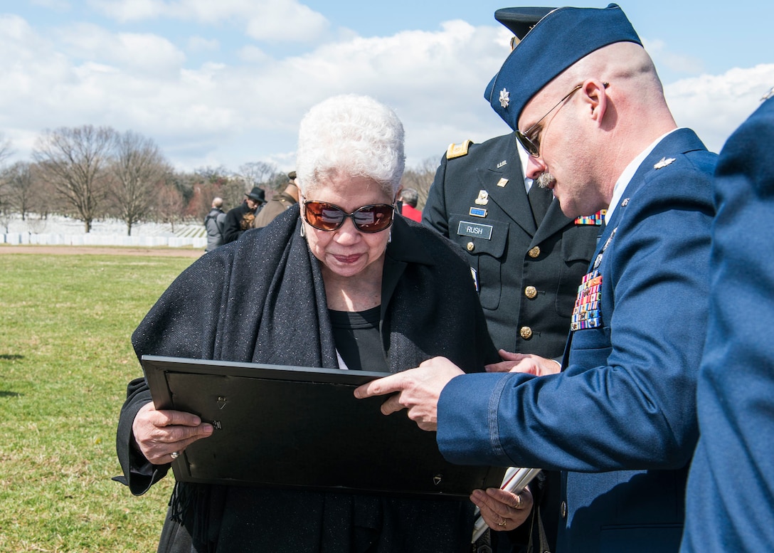 Lt Col Stimpson presents F-16 lithograph to Marla Andrews.