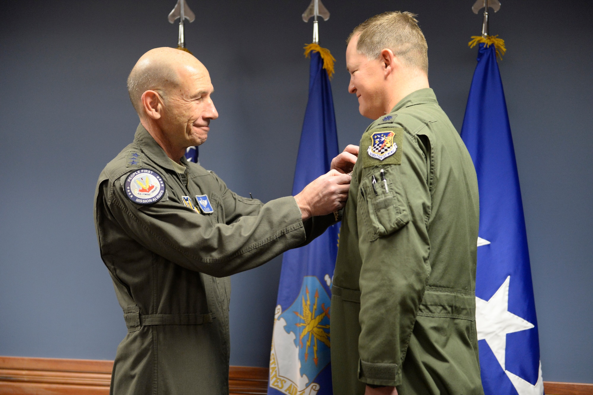 U.S. Air Force Gen. Mike Holmes, commander of Air Combat Command, presents the Distinguished Flying Cross to Lt. Col. Timothy “TJ” Eaton